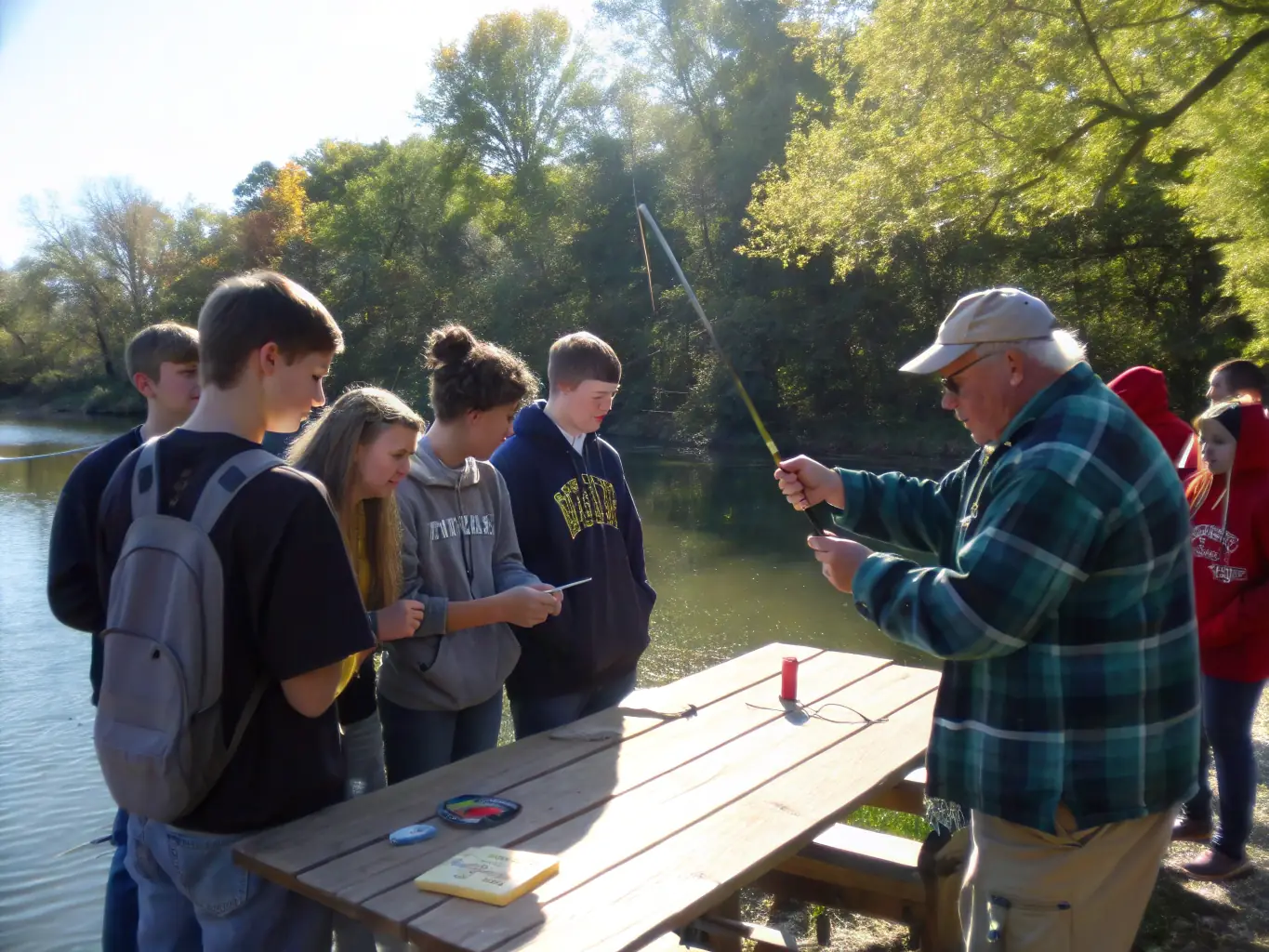 A group of people participating in a traditional fishing workshop, learning techniques from an experienced fisherman, highlighting the organization's efforts to preserve cultural heritage.